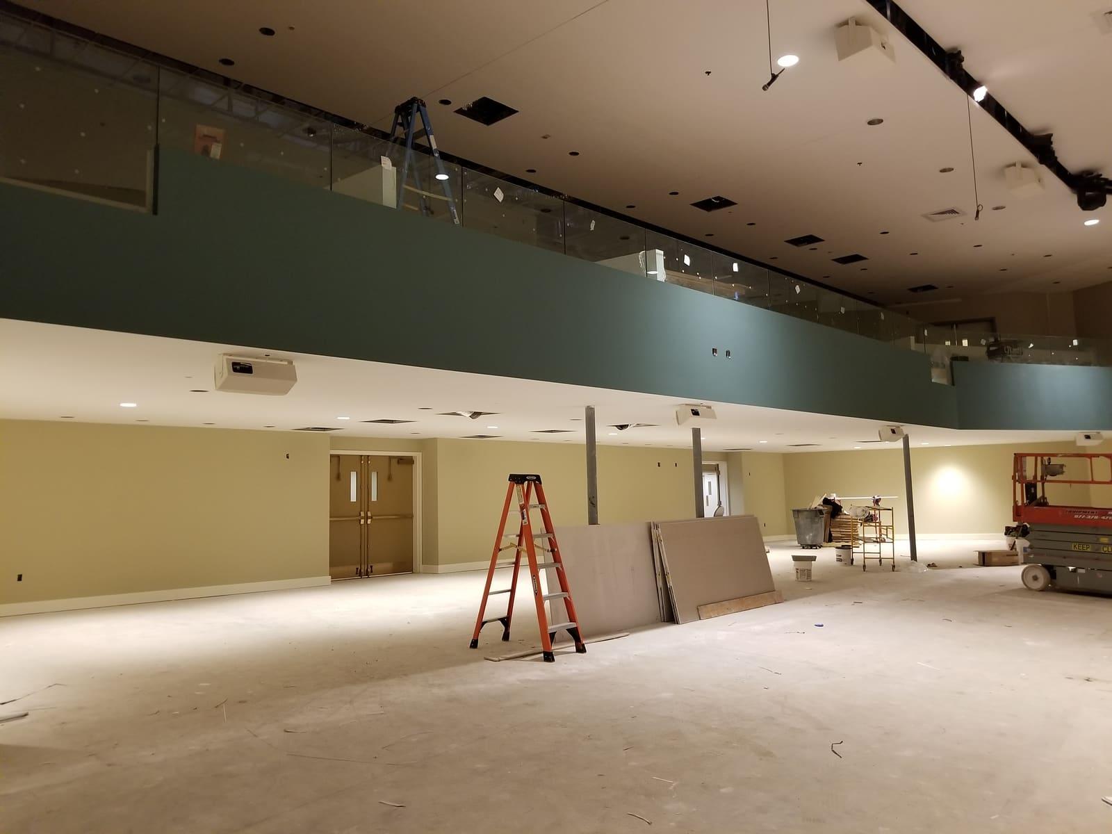 Large commercial interior with finished walls and a mezzanine balcony