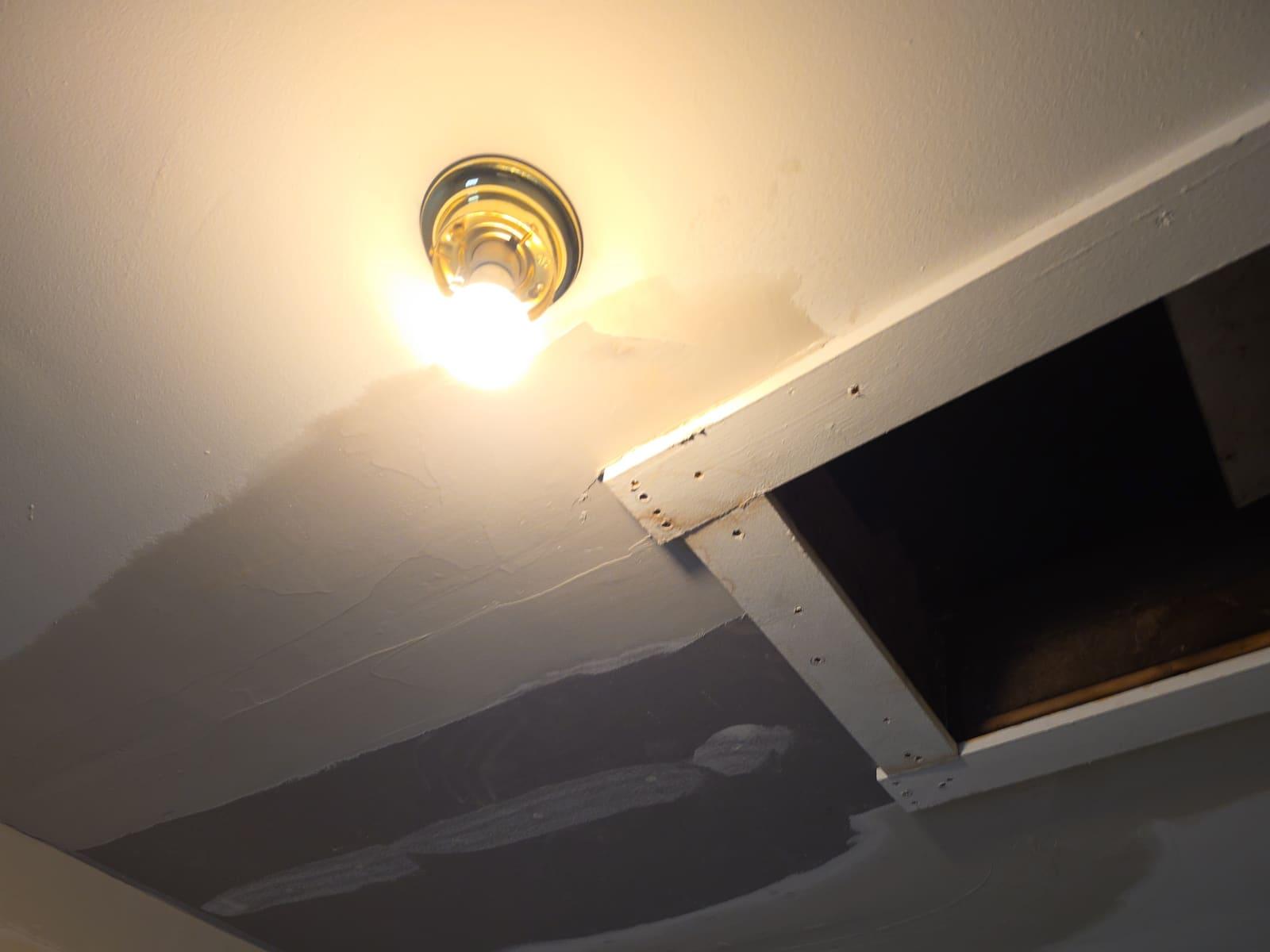 Ceiling drywall patch being blended in around an attic hatch